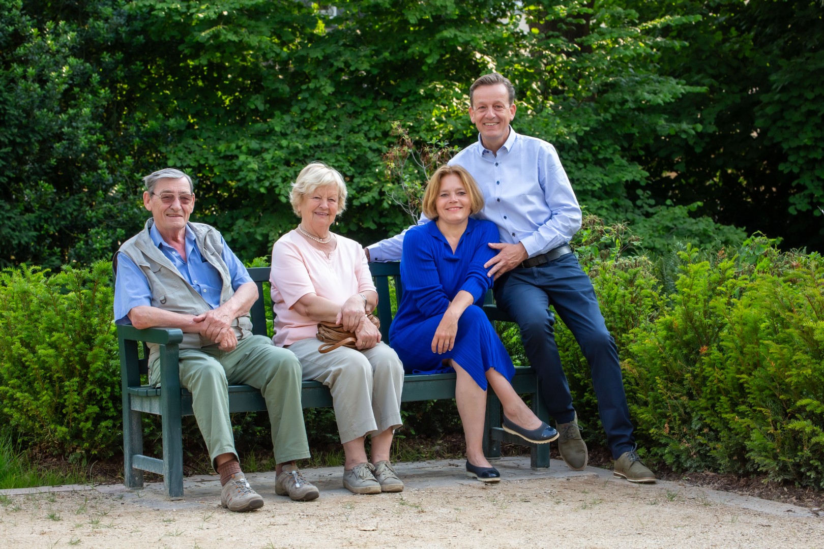 Rainer Vogt mit seiner Familie auf einer Bank in einem Park Rainer Vogt mit seiner Familie auf einer Bank in einem Park